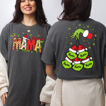 May include: A charcoal gray t-shirt featuring a graphic on the front that reads MAMA in red and green patterned letters with a Santa hat. The back displays a green hand holding five green character faces wearing Santa hats with Name text.