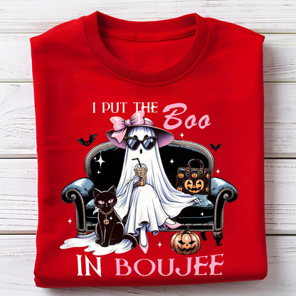 May include: A bright red t-shirt featuring a graphic of a white ghost wearing a pink bow, sunglasses, and holding a coffee cup while sitting on a black sofa next to a black cat and a pumpkin, with the text I PUT THE BOO IN BOUJEE printed.