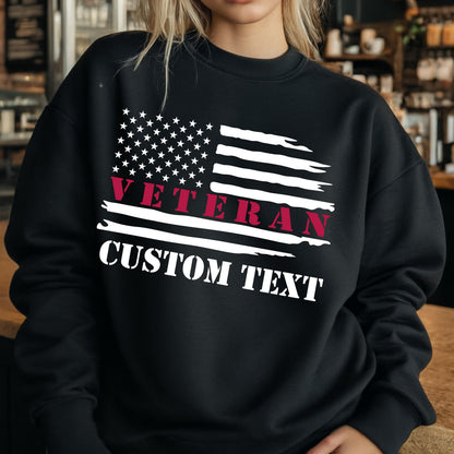 May include: Black sweatshirt featuring a distressed American flag design. The flag includes white stars and stripes, with the word "VETERAN" in red and "CUSTOM TEXT" in white. The sweatshirt is a crew neck style.