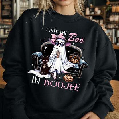 May include: A black crewneck sweatshirt featuring a graphic of a ghost wearing a pink bow, hat, and sunglasses, sitting on a sofa with a black cat, a pumpkin, and a handbag. The text reads I PUT THE BOO IN BOUJEE in white and pink lettering.