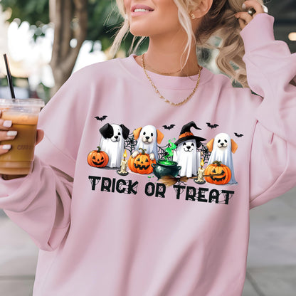 May include: A light pink sweatshirt featuring a Halloween-themed graphic. The graphic includes cartoon dogs dressed as ghosts, pumpkins, and a witch's hat, with the words "Trick or Treat" below. Bats are also included in the design.