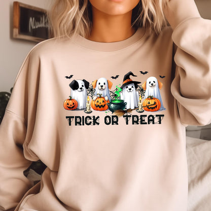 May include: Beige sweatshirt featuring a Halloween-themed graphic. The design includes four dogs dressed as ghosts, pumpkins, bats, candles, and a witch's cauldron. The words "TRICK OR TREAT" are printed in black block letters below the graphic.