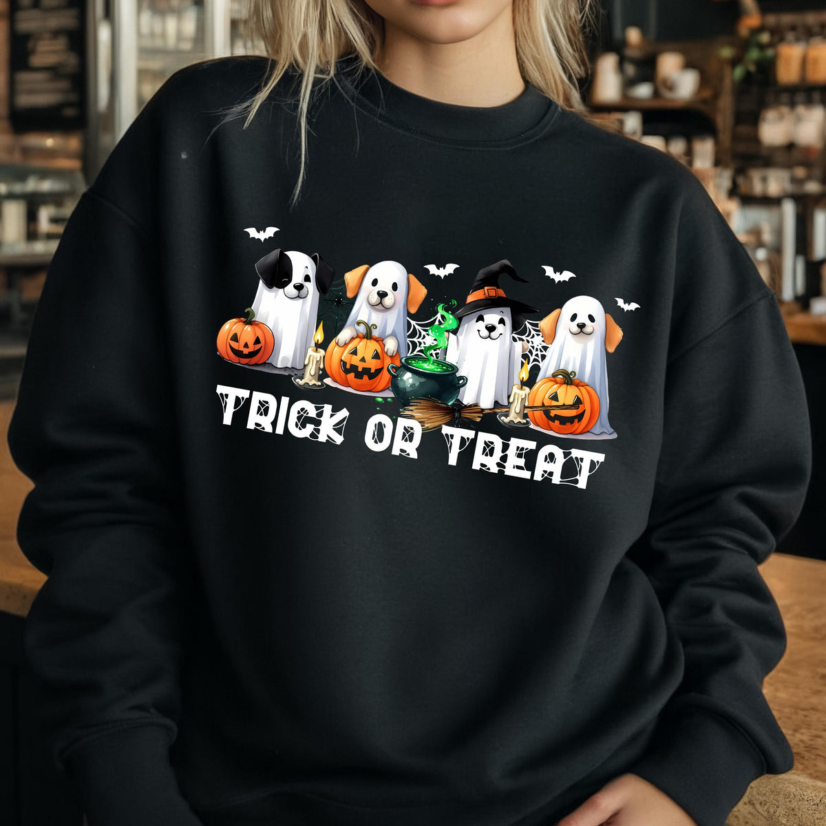May include: Black sweatshirt featuring a Halloween-themed graphic. The design includes four cartoon dogs dressed as ghosts, pumpkins, bats, and the text "TRICK OR TREAT" in white.
