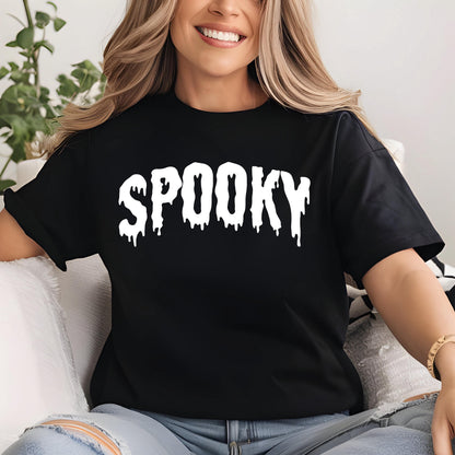 May include: Black t-shirt with the word "SPOOKY" in large, white, dripping letters. The shirt is a classic crew neck style. The text has a spooky, Halloween-themed design.