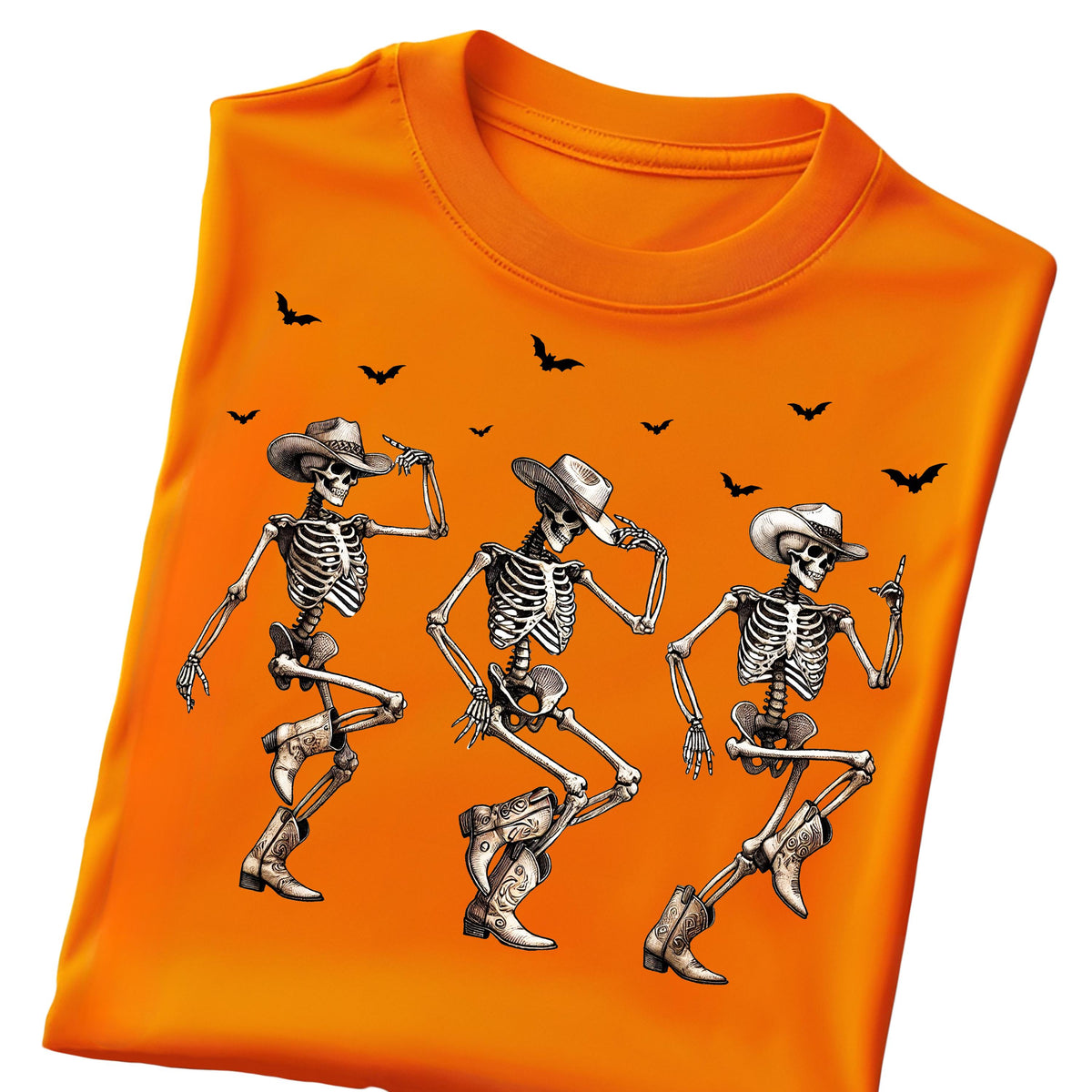 May include: Orange t-shirt featuring a graphic of three dancing skeletons wearing cowboy hats and boots. Black bats are scattered across the top. The design is perfect for Halloween or a fun, spooky look.