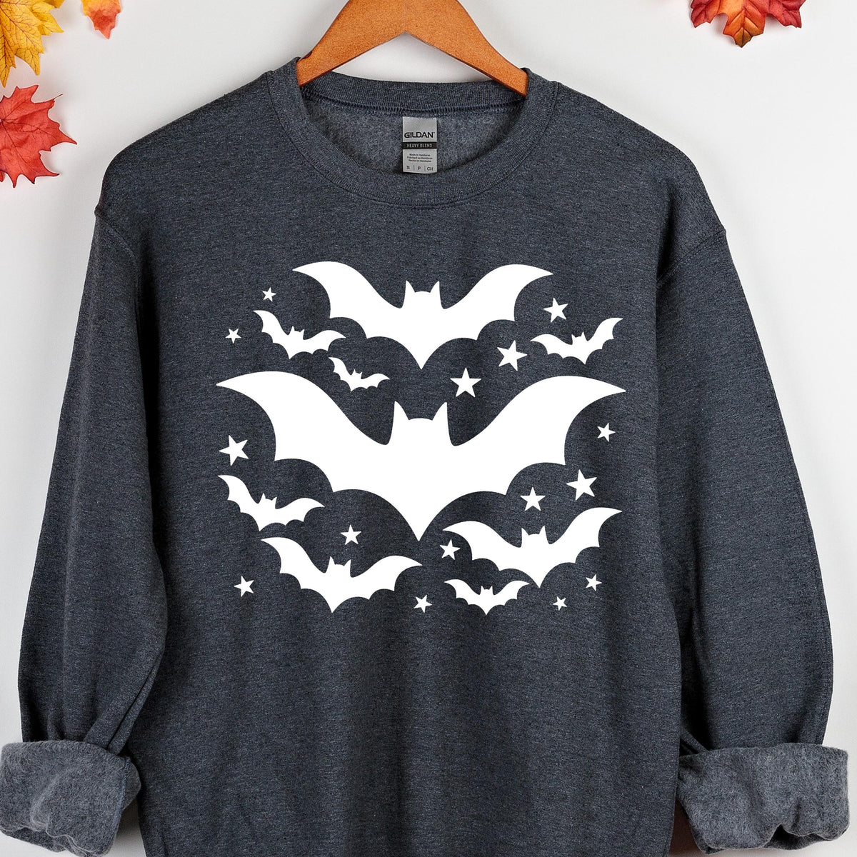 May include: Dark gray sweatshirt with a white bat and star design. The graphic features several bats of varying sizes and stars arranged in a circular pattern. The sweatshirt has a crew neck and long sleeves.