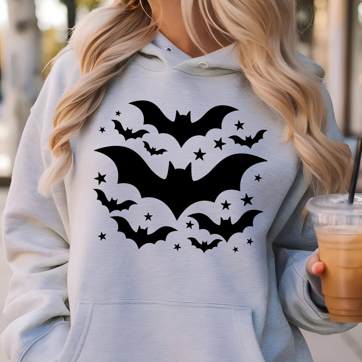 May include: A light gray hoodie featuring a black bat and star design. The graphic includes several bats of varying sizes and numerous small stars, creating a Halloween-themed aesthetic. The hoodie has a drawstring hood and a front pocket.