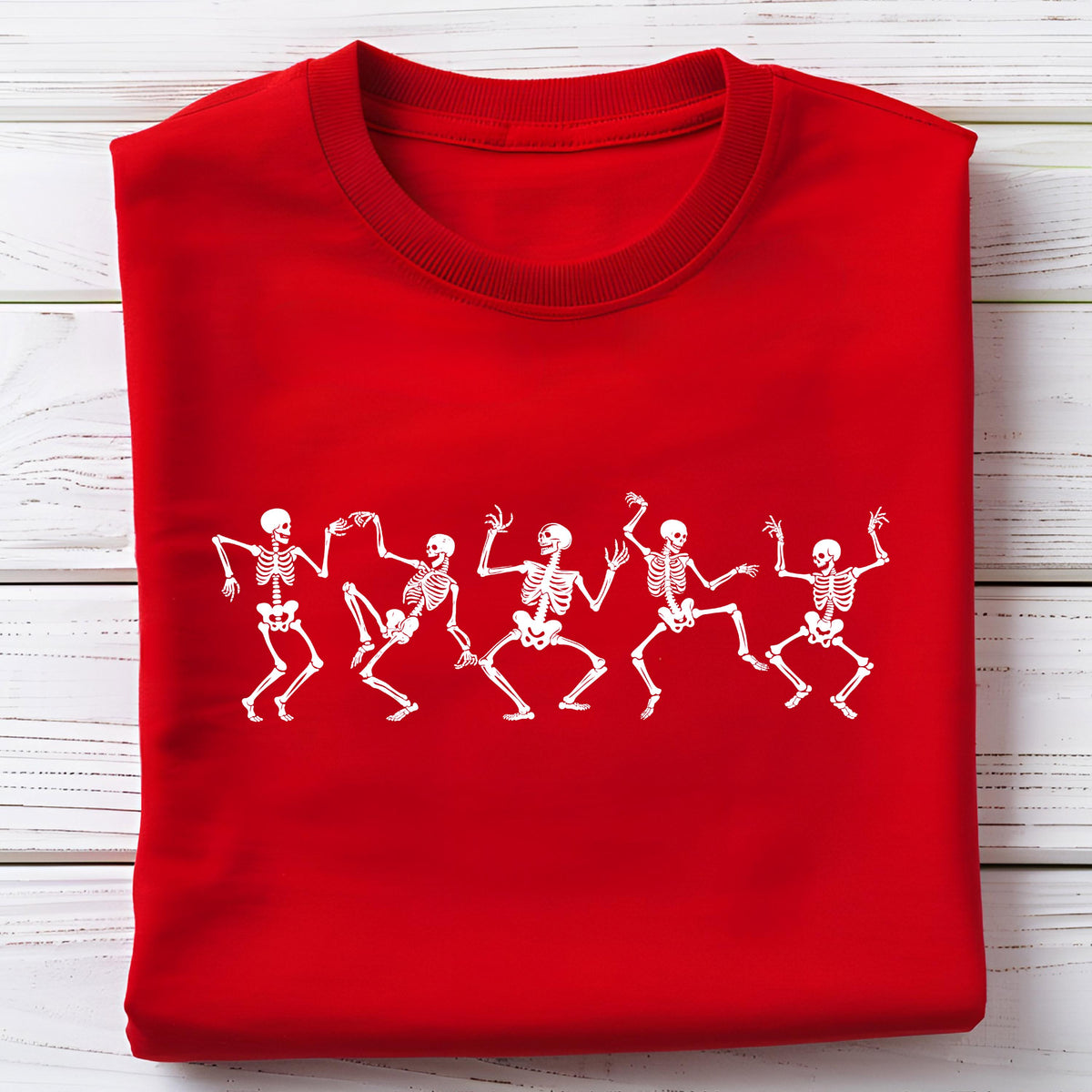 May include: A red sweatshirt featuring a white graphic of dancing skeletons. The skeletons are in various poses, with arms and legs outstretched. The sweatshirt has a crew neck and long sleeves. The design is centered on the front of the shirt.