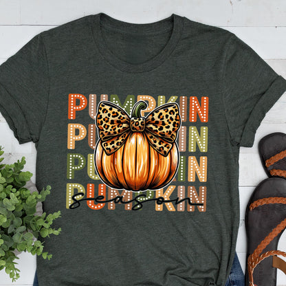 May include: Dark gray t-shirt featuring a pumpkin design with a leopard print bow and the words "PUMPKIN SEASON" in orange, green, and white. The pumpkin is orange with vertical lines. The shirt is a short-sleeved crew neck.