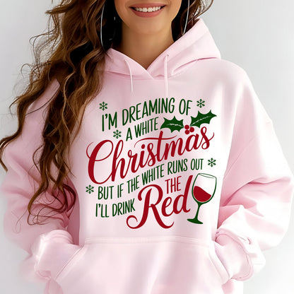 May include: A light pink hooded sweatshirt featuring a graphic print with green holly leaves and red berries, snowflakes, and a wine glass. The text reads: I'M DREAMING OF A WHITE CHRISTMAS BUT IF THE WHITE RUNS OUT I'LL DRINK THE RED.
