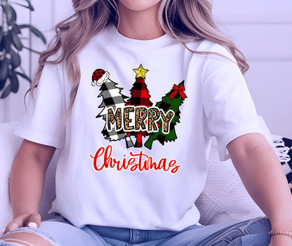 May include: A white short-sleeved t-shirt featuring a graphic of three stylized Christmas trees in black and white buffalo plaid, red and black buffalo plaid, and green plaid. The word MERRY is in leopard print, and Christmas is in red script.