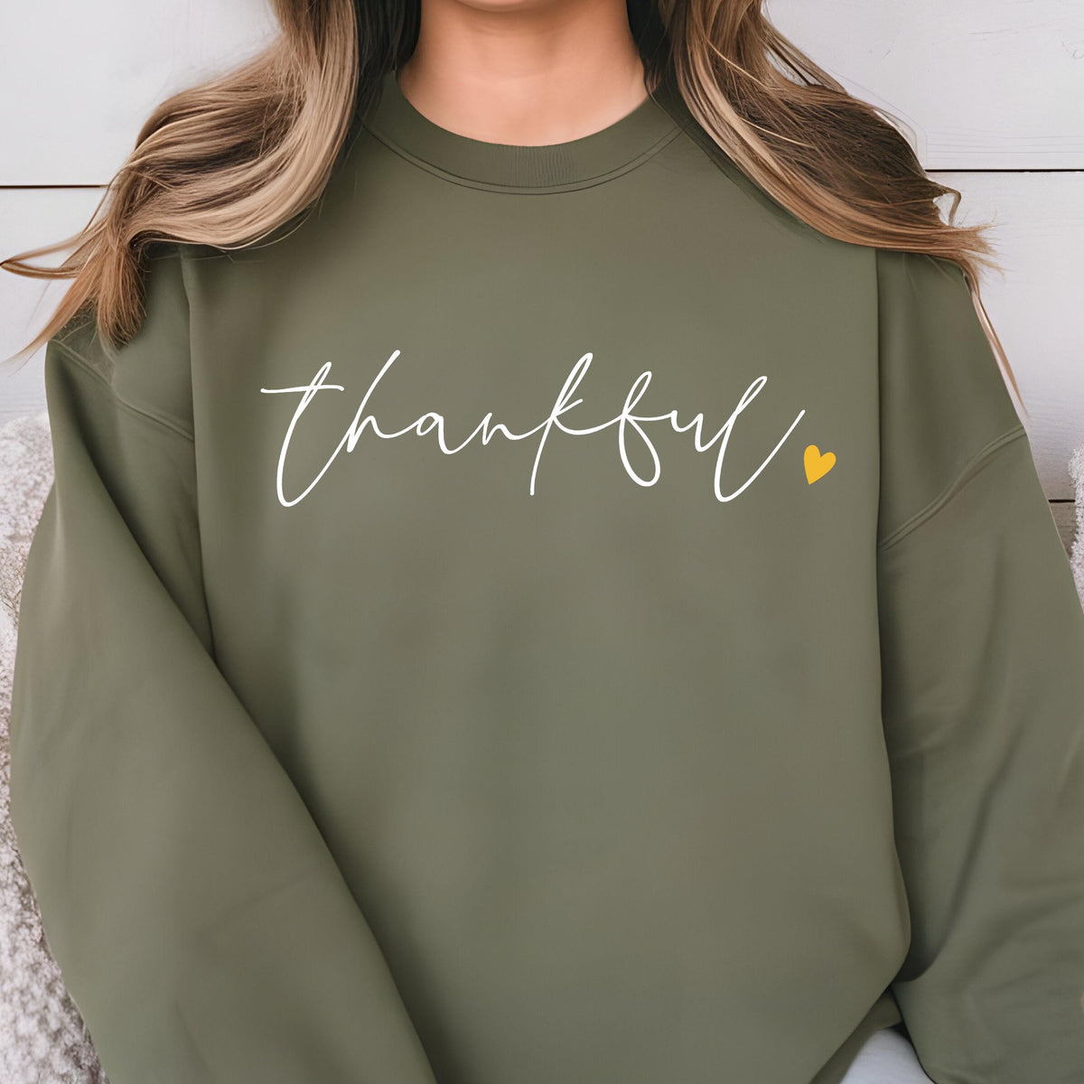 May include: A green sweatshirt with the word "thankful" written in white script with a small yellow heart.