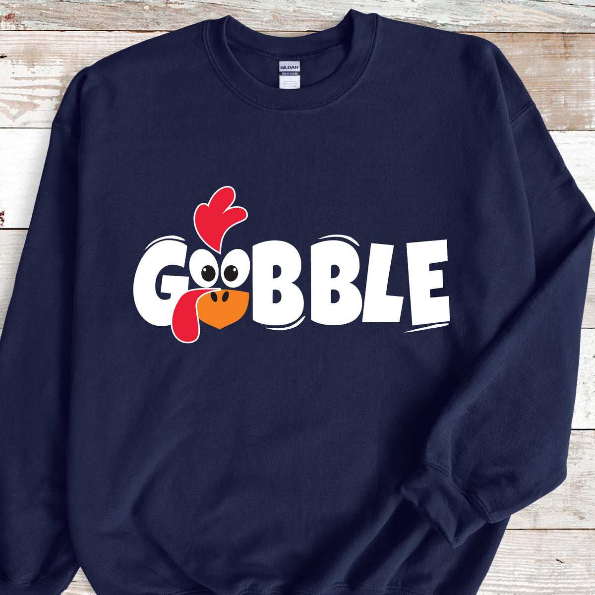 May include: Navy blue sweatshirt with a white graphic of a turkey head and the word "GOBBLE" in white letters.