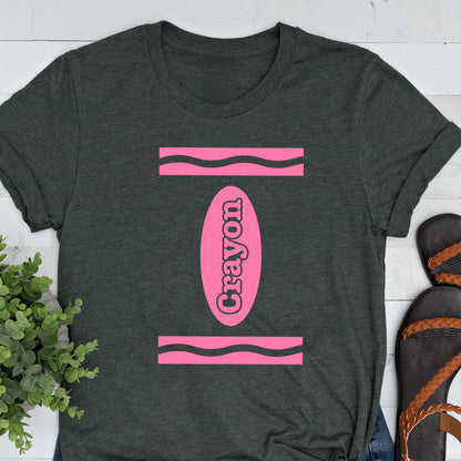 May include: A dark gray t-shirt with a pink crayon design. The crayon is outlined in black and the word "Crayon" is written inside the crayon.