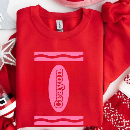 May include: Red sweatshirt with a pink crayon design and the word "Crayon" written inside the crayon.