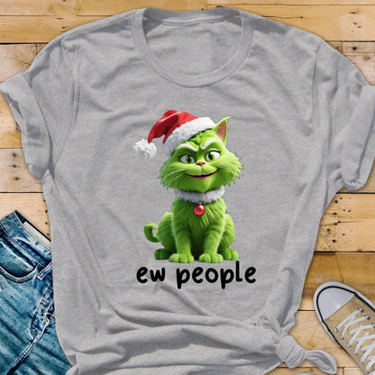 May include: A light gray short-sleeved t-shirt featuring a graphic of a green cat wearing a red and white Santa hat and a red ornament collar. Below the cat, the text "ew people" is printed in black, lowercase, sans-serif lettering.
