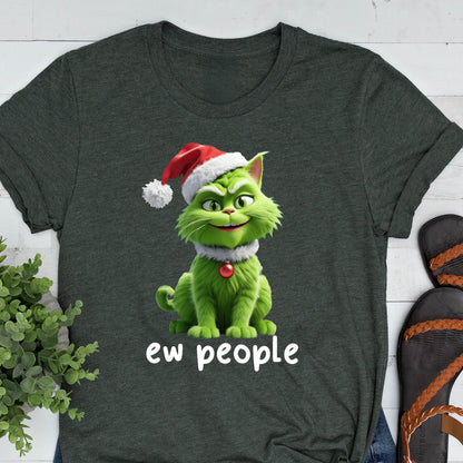May include: A dark heather gray t-shirt featuring a graphic of a green cat wearing a red and white Santa hat and a red ornament collar. The cat has a mischievous expression, and the text "ew people" is printed in white below the illustration.