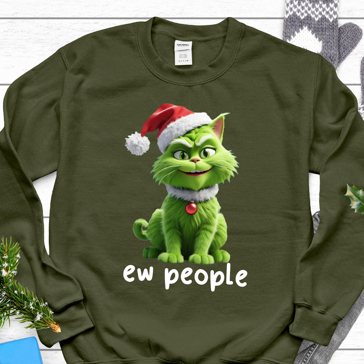 May include: Olive green sweatshirt featuring a green cat character wearing a Santa hat and a white collar with a red ornament. The text "ew people" is printed in white below the cat.