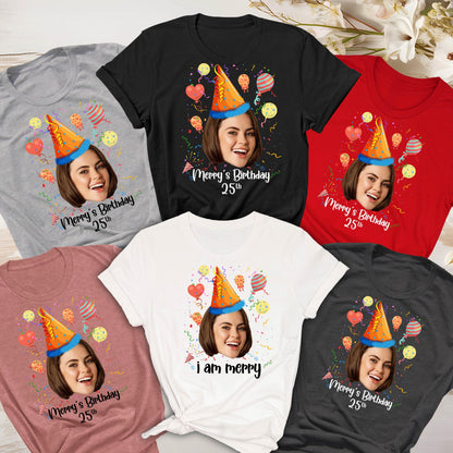 May include: A collection of six t-shirts in gray, black, red, pink, white, and dark gray. Each shirt features a graphic of a person wearing a blue and orange party hat, surrounded by colorful balloons and confetti, with the text Merry's Birthday 25th.