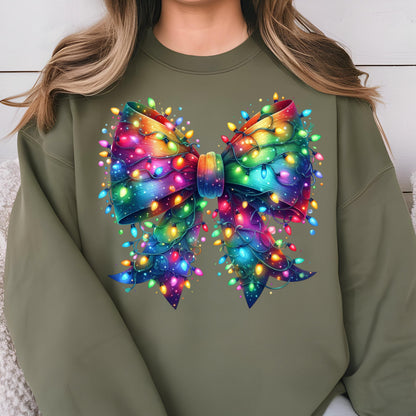 May include: An olive green crewneck sweatshirt featuring a large, central graphic of a bow. The bow is decorated with a vibrant, multi-colored rainbow gradient and is wrapped in glowing, multi-colored string lights in red, blue, and yellow.