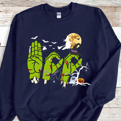 May include: Navy blue sweatshirt with a Halloween-themed graphic. The design features green zombie hands spelling out "BOO" in American Sign Language, with bats, a full moon, a witch's hat, and a jack-o'-lantern.
