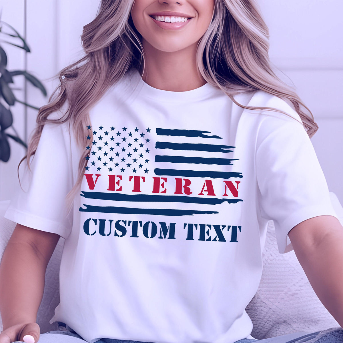 May include: White t-shirt featuring a stylized American flag design. The flag incorporates a field of blue stars and red and blue stripes. The word "VETERAN" is in red, and "CUSTOM TEXT" is in blue.