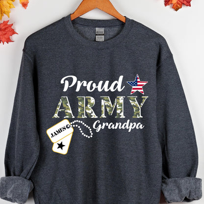May include: Dark gray sweatshirt with the words "Proud ARMY Grandpa" in white script and camouflage lettering. A dog tag with the name "JAMES" is also visible. A red, white, and blue star graphic is on the right side of the sweatshirt.