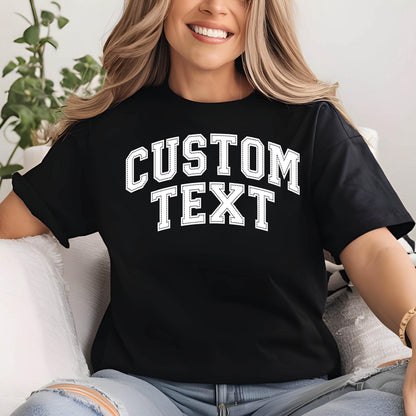 May include: Black t-shirt with the text "CUSTOM TEXT" in a white, collegiate-style font. The shirt has short sleeves and a relaxed fit. The text is outlined with a dotted border.