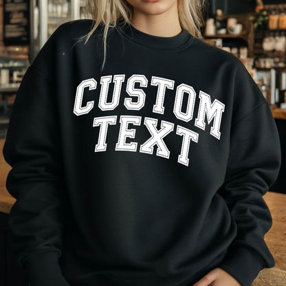 May include: Black sweatshirt with white text that says "CUSTOM TEXT" in a varsity style font.