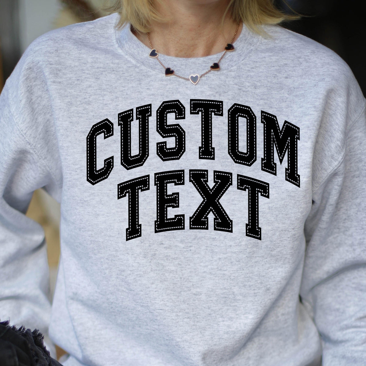 May include: Gray sweatshirt with black text that reads "CUSTOM TEXT" in a varsity style font.
