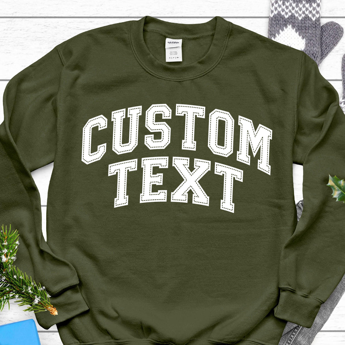 May include: A green sweatshirt with white text that says "CUSTOM TEXT" in a varsity style font.