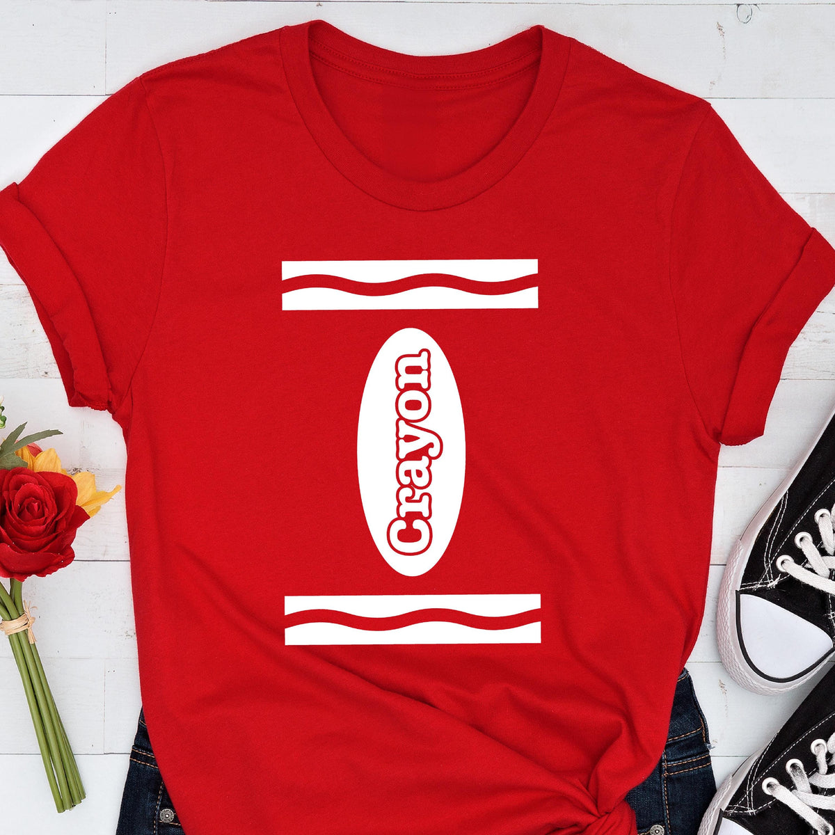 May include: Red t-shirt with a white crayon design. The design includes the word "crayon" and wavy lines.
