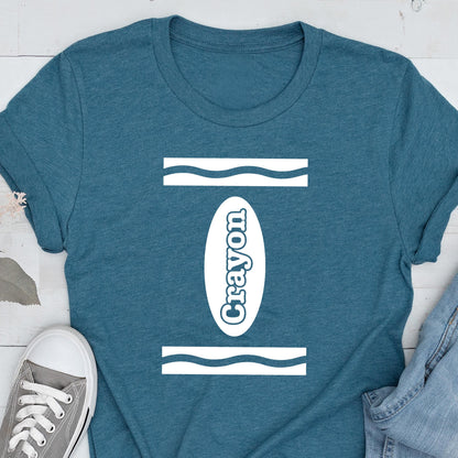 May include: A teal blue t-shirt with a white crayon design. The design features a white oval with the word "Crayon" written inside. The oval is surrounded by two white wavy lines.