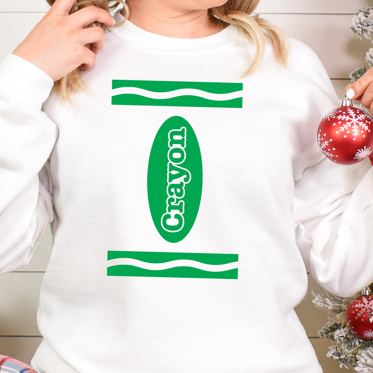 May include: White sweatshirt with a green crayon design and the word "Crayon" written vertically inside the crayon.