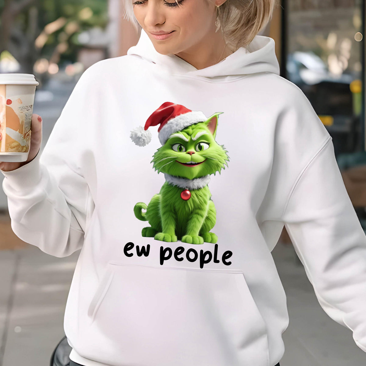 May include: White hoodie featuring a green cartoon cat wearing a Santa hat and a red collar. The cat has a mischievous grin. Below the cat is the text "ew people".