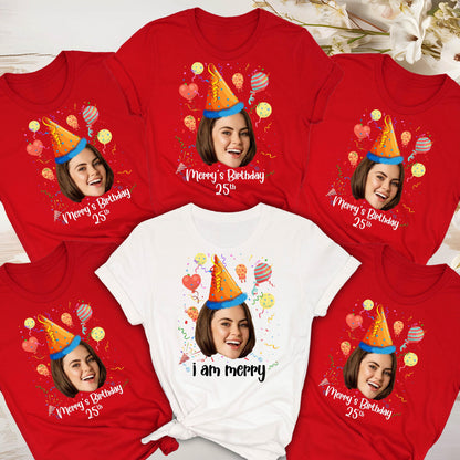 May include: Five red t-shirts with a white t-shirt in the center. Each shirt features a cartoon face with a party hat and balloons. The text on the red shirts reads "Merry's Birthday 25th". The text on the white shirt reads "I am Merry".