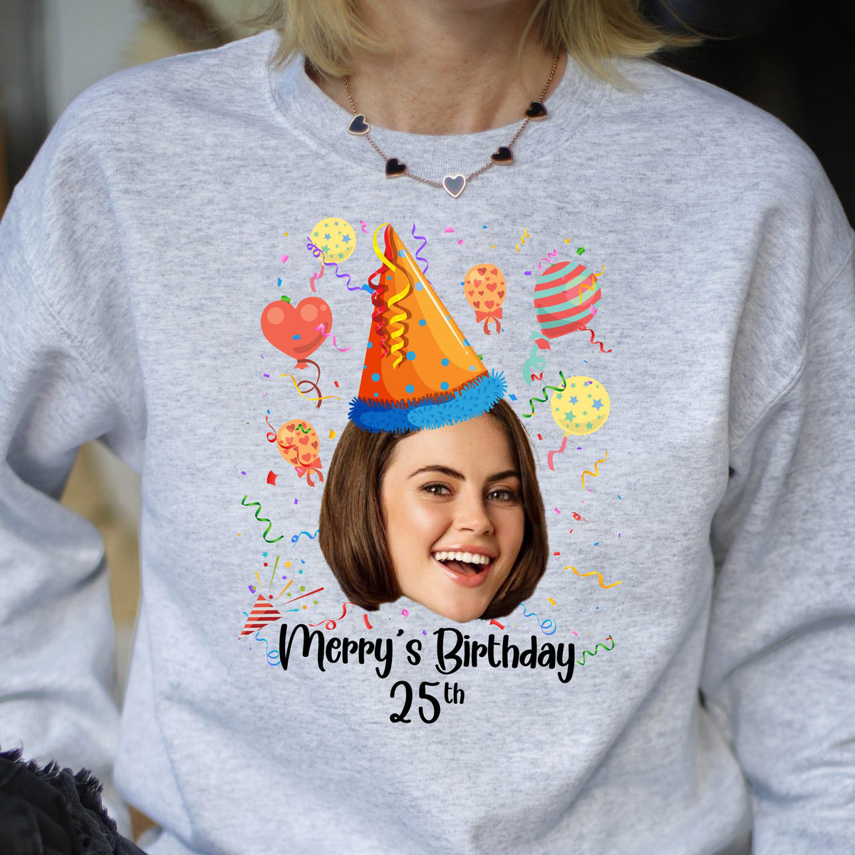 May include: A gray sweatshirt with a colorful birthday design. The design features a person's face with a party hat, confetti, and balloons. The text "Merry's Birthday 25th" is printed below the design.