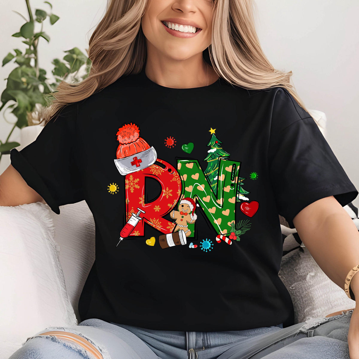 May include: Black t-shirt with a colorful Christmas-themed design featuring the letters "RN" in red and green. The design includes a nurse's hat, Christmas tree, gingerbread man, syringe, and coffee cup. The shirt is a crew neck.