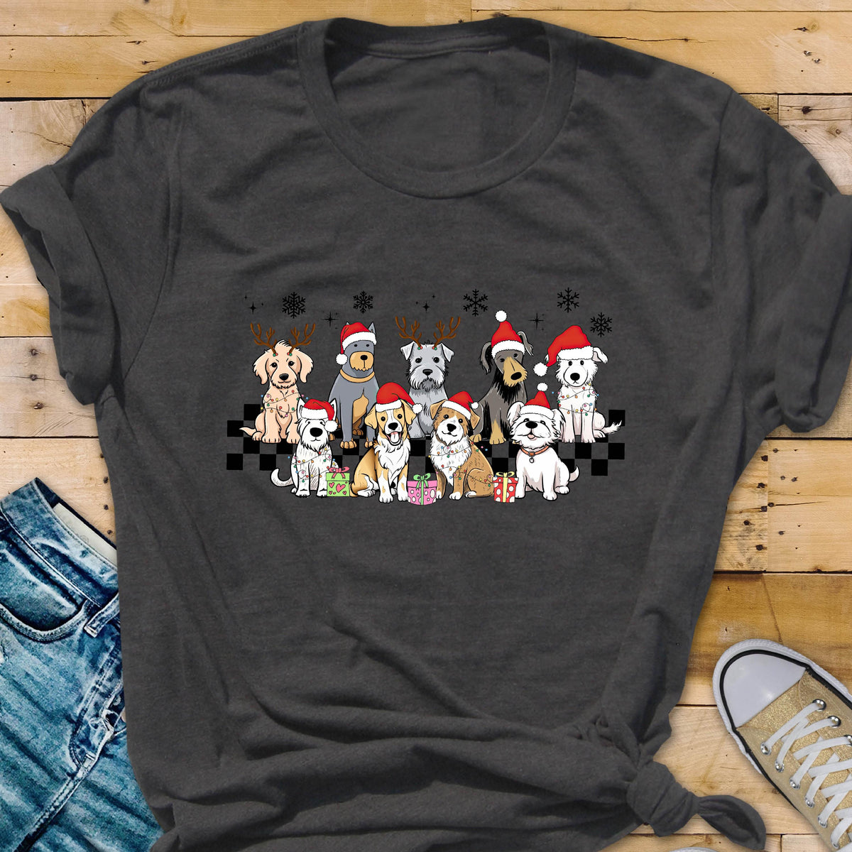 May include: Dark gray t-shirt featuring a festive graphic of various dog breeds wearing Santa hats and reindeer antlers. The dogs are arranged in a row with snowflakes and gift boxes, creating a holiday theme.