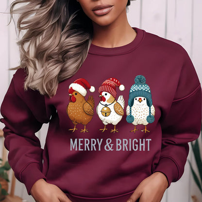 May include: A maroon sweatshirt with a Christmas-themed design featuring three chickens wearing festive hats. The chickens are brown, white, and white with blue accents. The text "Merry & Bright" is printed below the chickens.