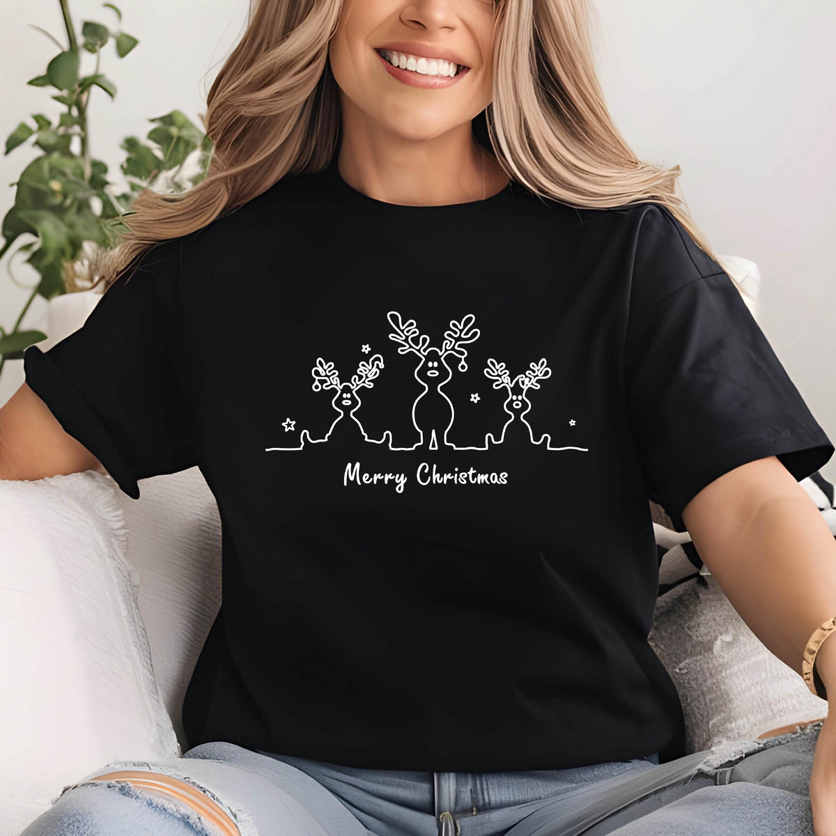 May include: Black t-shirt with a white line drawing of three reindeer with antlers and the text "Merry Christmas" below. The reindeer are stylized with simple shapes and star accents.