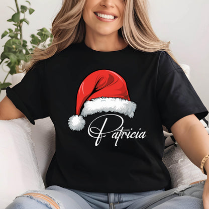 May include: A black short-sleeved t-shirt featuring a graphic of a red Santa hat with white fur trim. Below the hat, the name Patricia is printed in a white cursive script font. The shirt has a crew neckline and a standard fit design.