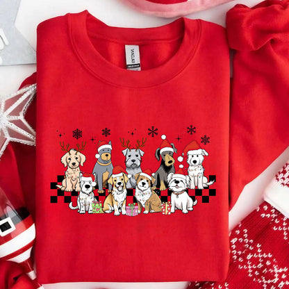 May include: Red sweatshirt featuring a festive design of various dog breeds wearing Santa hats and reindeer antlers. The dogs are arranged in a row above a black and white checkered pattern, with snowflakes and gifts. A holiday-themed apparel item.