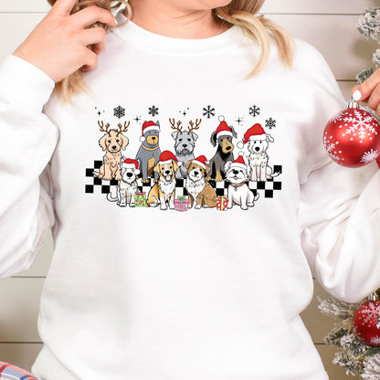 May include: White sweatshirt featuring a festive design of various dog breeds wearing Santa hats and reindeer antlers. The dogs are arranged on a black and white checkered pattern, with snowflakes and wrapped gifts. A cheerful holiday theme.