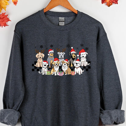 May include: Dark gray sweatshirt featuring a festive graphic of various dog breeds wearing Santa hats and reindeer antlers. The dogs are arranged in a row with snowflakes above and gifts below, creating a holiday theme. The sweatshirt has a crew neck and long sleeves.