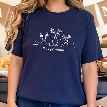 May include: Navy blue t-shirt featuring a white line drawing of three reindeer with star accents. The text "Merry Christmas" is written below the reindeer design. A festive holiday-themed apparel item.