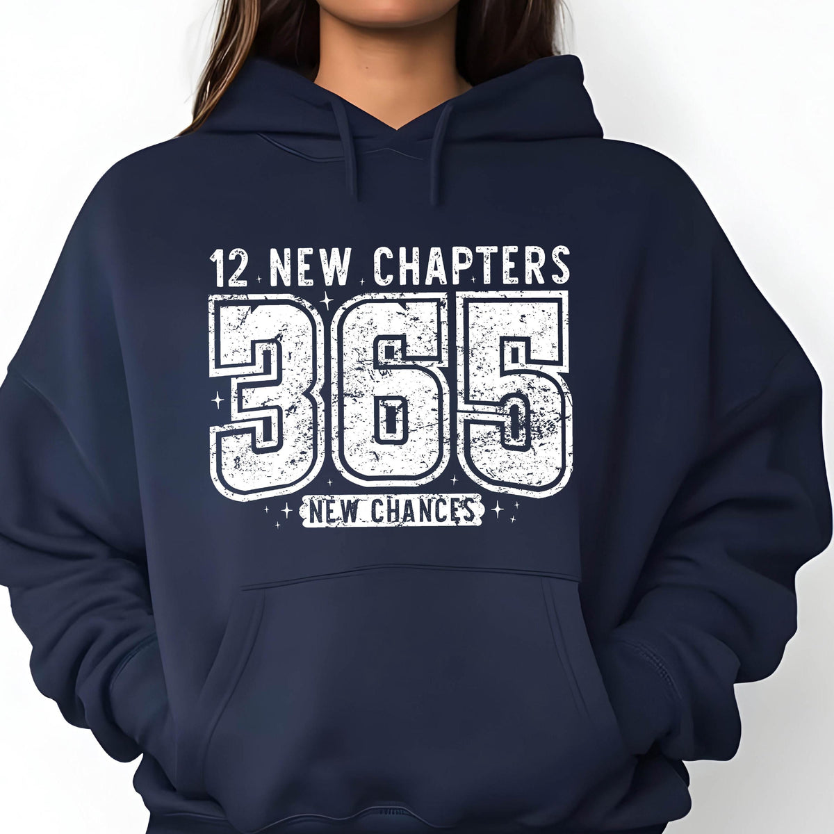 May include: Navy blue hoodie with a white distressed print. The print reads "12 NEW CHAPTERS 365 NEW CHANCES" in a bold, stylized font. The hoodie has a front pocket and a drawstring hood.