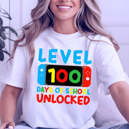 May include: White t-shirt with a blue, red, yellow, and green graphic of a video game controller with the text "Level 100 Days of School Unlocked".