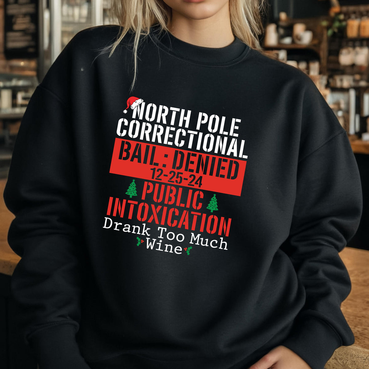 May include: Black sweatshirt with the text "NORTH POLE CORRECTIONAL BAIL: DENIED 12-25-24 PUBLIC INTOXICATION Drank Too Much Wine". The text is in white and red, with a Santa hat and Christmas tree graphics.