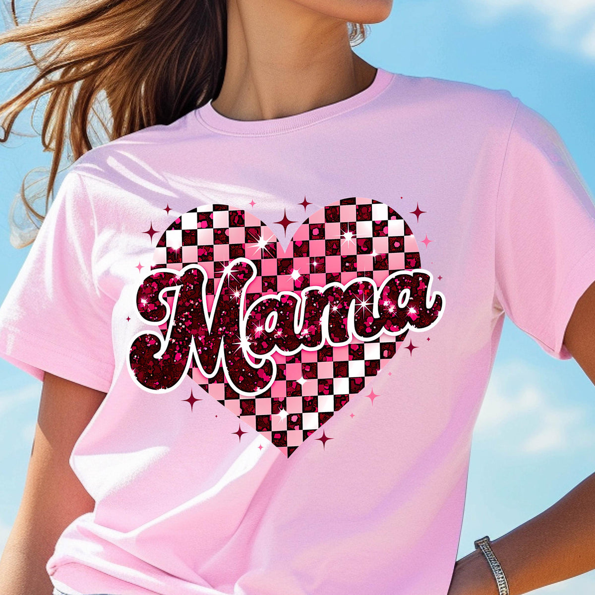 May include: Pink t-shirt with a pink and black checkered heart design and the word "Mama" in sparkly pink letters.